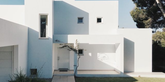 white concrete house near green tree during daytime